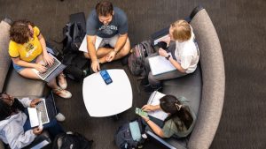 students sitting on couches at a table bird's eye view
